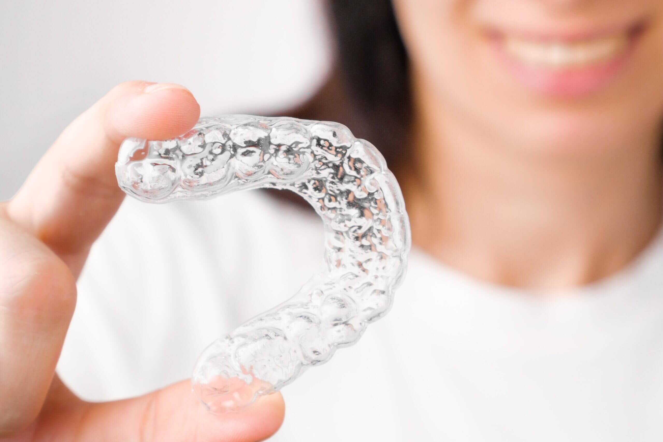 close up orthodontic transparent aligner in womans image